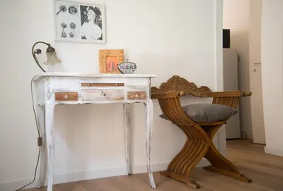 a white console table with a chair next to it at via pannieri apartament in Palermo