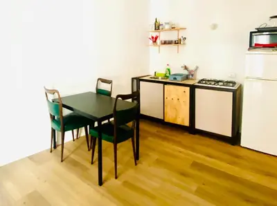 a kitchen with a table and chairs and a refrigerator at via pannieri apartament in Palermo