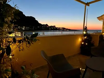 a balcony with a chair and a view of the ocean at La casetta al mare in Palermo