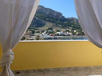 a window with a view of the ocean and mountains at La casetta al mare in Palermo