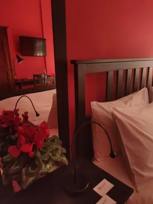 a bedroom with a bed with red walls and a table with flowers at B&B Rodionoff Palermo View & Terrace Mondello-Airport Link in Palermo