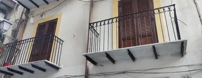 a building with two balconies and a balcony with windows at The traveler's house in Palermo