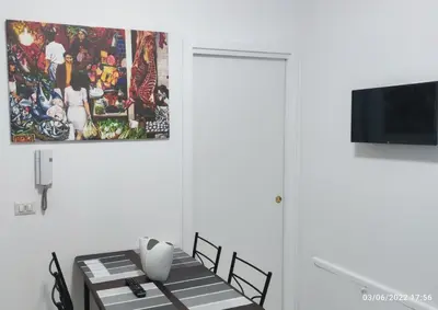 a dining room with a table and a painting on the wall at The traveler's house in Palermo