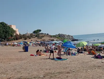 a group of people on a beach with umbrellas at Lumera in Santa Flavia