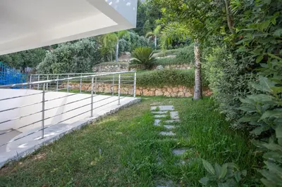 a garden with rocks in the grass next to a fence at Mondello Addaura Addisio Suite in Palermo
