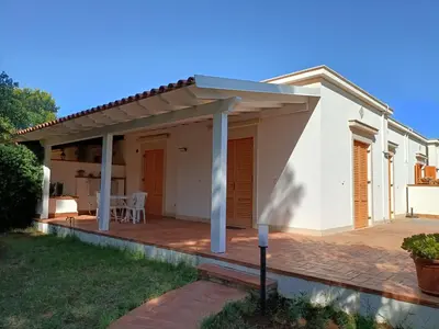 a white house with a pergola on a patio at Chalet Calarossa in Terrasini