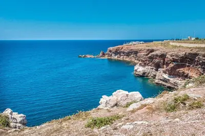 a large body of water next to a rocky cliff at Chalet Calarossa in Terrasini