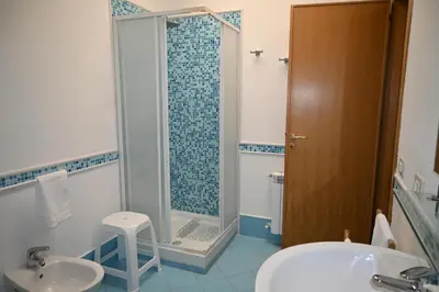 a bathroom with a shower and a sink and a toilet at Chalet Calarossa in Terrasini