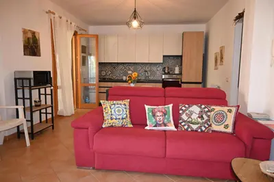 a red couch with pillows in a living room at Chalet Calarossa in Terrasini