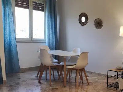 a table and chairs in a room with a window at Amunì in Palermo