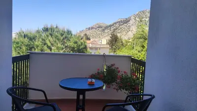 a blue table and chairs on a balcony with mountains at Amunì in Palermo