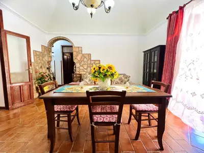 a dining room table with a vase of flowers on it at Nonna Sasà in Torretta