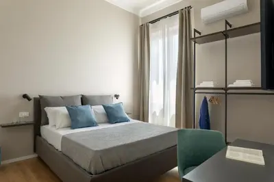 a bedroom with a bed with blue pillows at Mori's Rooms in Palermo