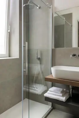 a bathroom with a glass shower and a sink at Mori's Rooms in Palermo