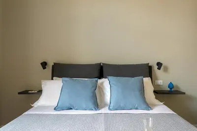 a bed with two blue pillows on top of it at Mori's Rooms in Palermo