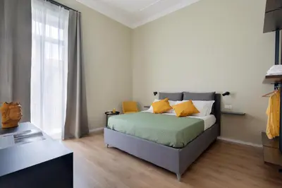 a bedroom with a bed and a large window at Mori's Rooms in Palermo