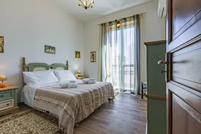 a bedroom with a bed and a large window at GuestHost - Terry's Garden in Palermo in Palermo