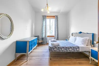a bedroom with a blue bed and a mirror at GuestHost - Terry's Garden in Palermo in Palermo