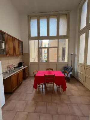 a kitchen with a table with a red table cloth on it at Nowhere Rooms in Palermo