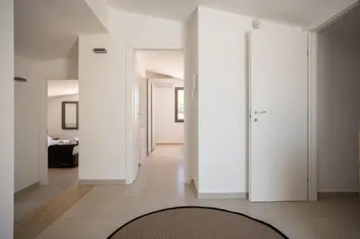 a hallway with white walls and a rug at Grande Villa privata con piscina a Scopello in Castellammare del Golfo