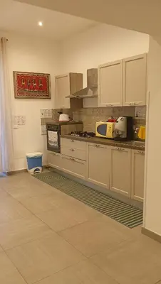 a kitchen with white cabinets and a counter top at Lilibet Apartment in Palermo