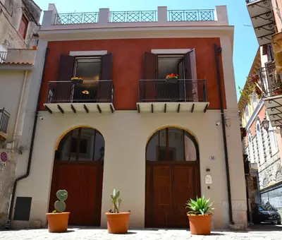 a red and white house with two balconies at Isula in Palermo