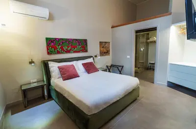 a bedroom with a bed with two red pillows at Isula in Palermo
