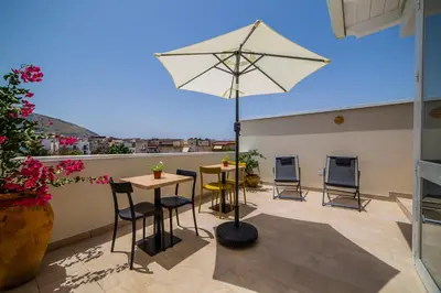 a patio with a table and chairs and an umbrella at Ciuri' Affittacamere in Alcamo