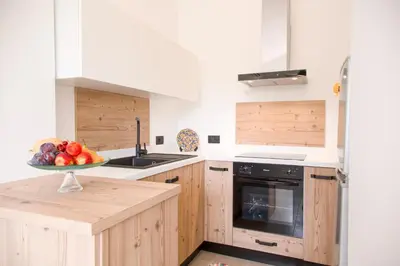 a kitchen with wooden cabinets and a bowl of fruit at Ciuri' Affittacamere in Alcamo