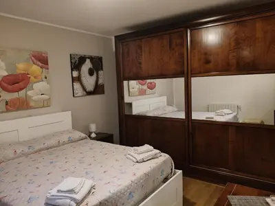 a bedroom with a bed and a large wooden cabinet at Casabella Mondello in Mondello