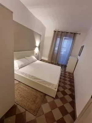 a small bedroom with a white bed and a window at Domus Sant'Anna Apartment in Palermo