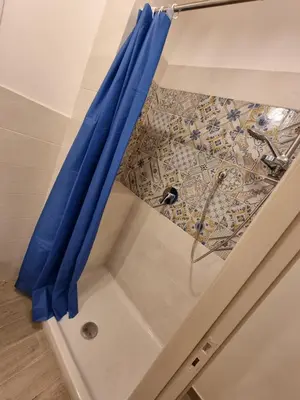 a blue curtain in a room with a tile floor at Domus Sant'Anna Apartment in Palermo
