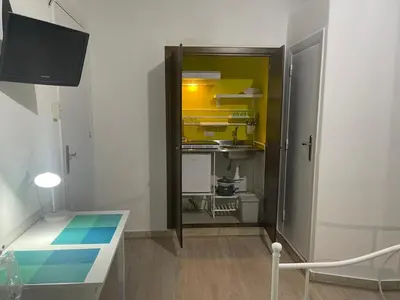 a small room with a table and a kitchen at Casa Vittoria in Palermo