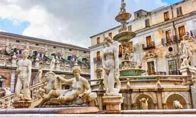 a fountain with statues in front of a building at Casa Pascal in Palermo