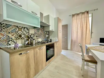 a kitchen with wooden cabinets and a dining table at Casa Pascal in Palermo