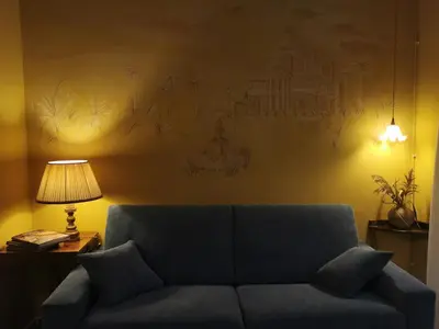 a blue couch in a living room with a lamp at Dimora Lecerf in Palermo
