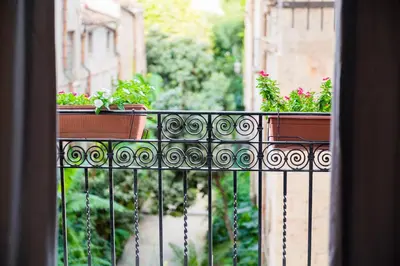 a balcony with two plants on a fence at AUSA suites in Palermo