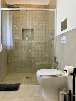 a bathroom with a toilet and a glass shower at Katy's Holiday House, Private Villa and Pool in Terrasini