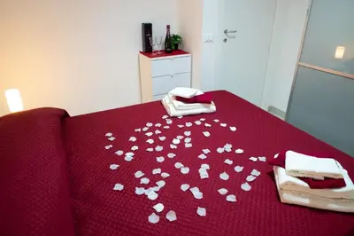 a table with white hearts on a red blanket at Casa d'a-mare in Terrasini