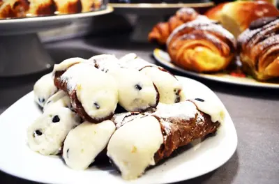 a white plate with a piece of cake and other pastries at B&B Casa Canali in Palermo