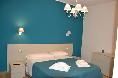 a blue bedroom with a bed with two towels on it at Villa del Principe in Carini