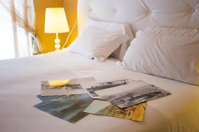 a bed with two books on top of it at Hotel Posta in Palermo
