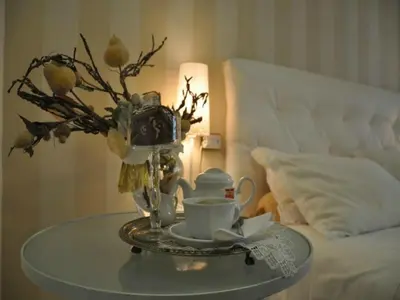 a glass table with a cup and a camera on a bed at Hotel Posta in Palermo