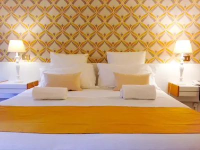a bedroom with a large bed with two tables and two lamps at Hotel Posta in Palermo