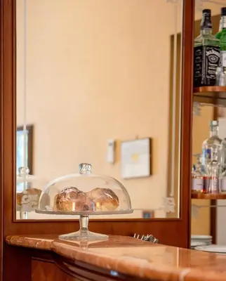 a glass plate with two pastries on a counter at Massimo Plaza Hotel in Palermo