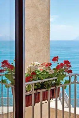 a balcony with a bunch of flowers on a railing at Hotel Al Madarig in Castellammare del Golfo