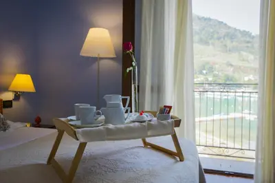 a hotel room with a bed with a tray of food on it at Hotel Cetarium in Castellammare del Golfo