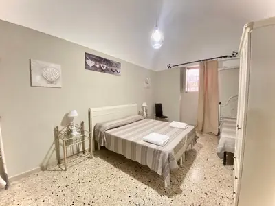 a white bedroom with a bed and a mirror at La Ginestra in Corleone