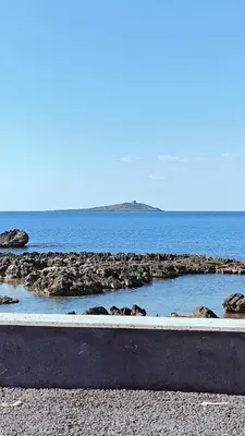 a large body of water with rocks on a beach at Casa il Bergamotto in Palermo