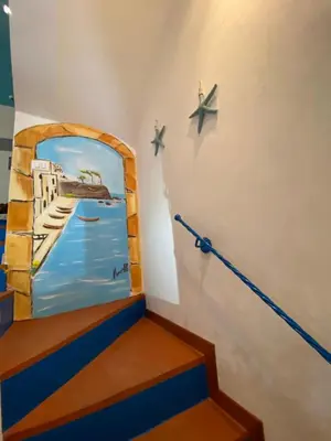 a painting on the wall of a room with stairs at Casa vacanze stella marina in Trappeto